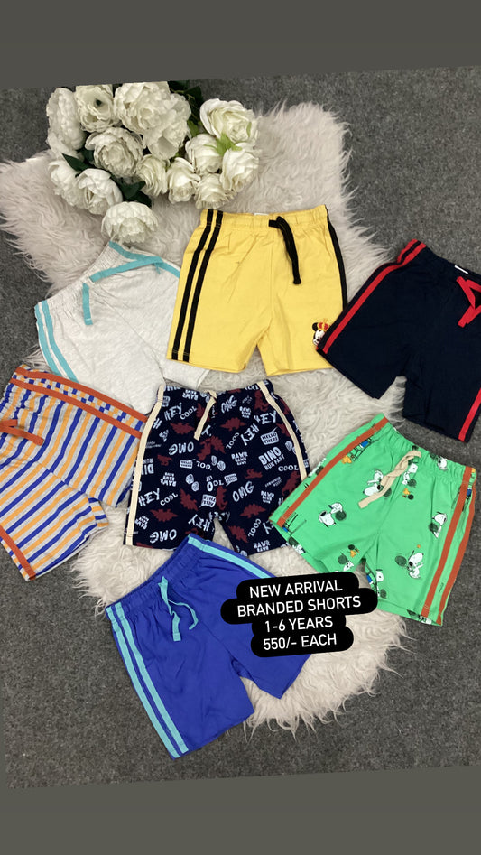 Collection of children's shorts on a textured surface with flowers in the background.