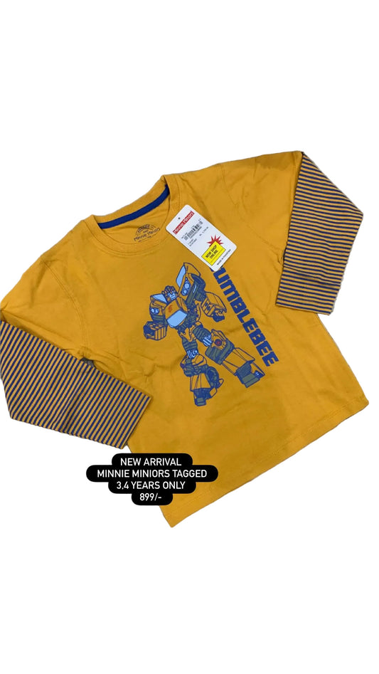 Yellow shirt with robot design on a textured surface with flowers in the background