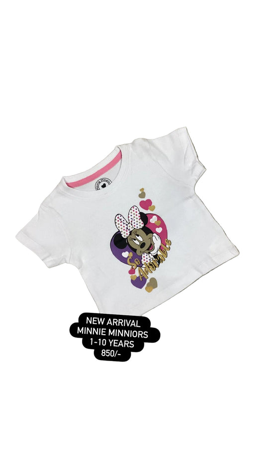 White t-shirt with Minnie Mouse design on a textured surface with flowers in the background