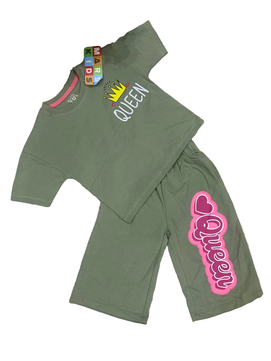 Green children's outfit with 'Queen' text on a fluffy white surface