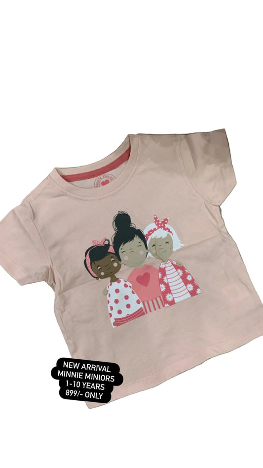 Pink t-shirt with cartoon characters on a textured surface with flowers in the background