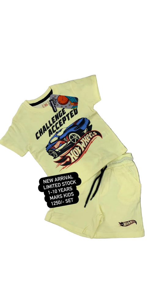 Yellow t-shirt with graphic design and text on a textured surface with flowers in the background