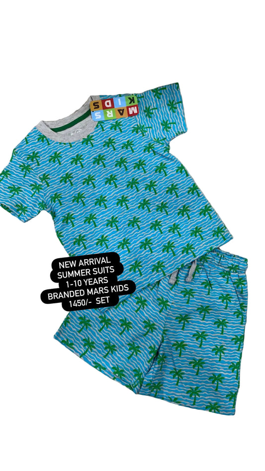 Children's blue and green palm tree patterned suit on a textured surface with flowers in the background.