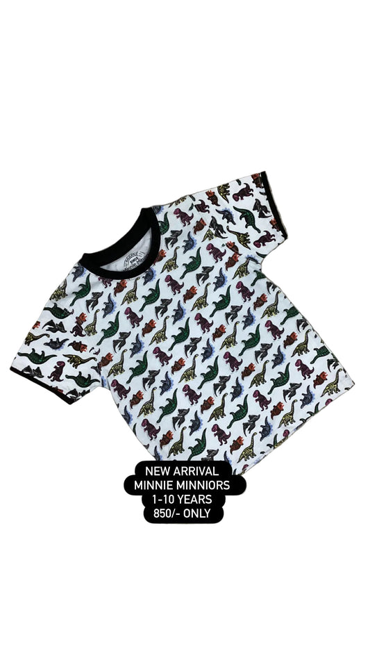 Children's outfit with dinosaur pattern on a textured surface with flowers in the background
