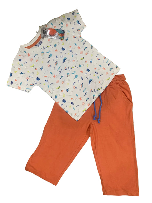 Children's outfit with a patterned top and orange pants on a textured surface