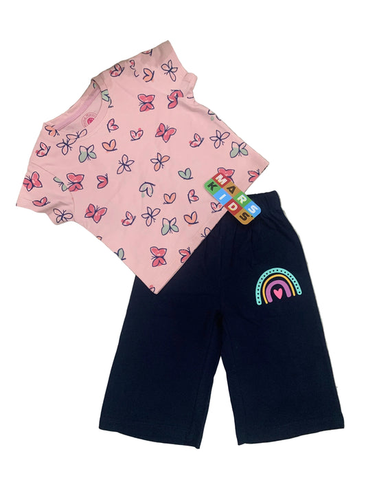 Pink shirt with butterfly pattern and navy shorts with rainbow design on a textured surface.